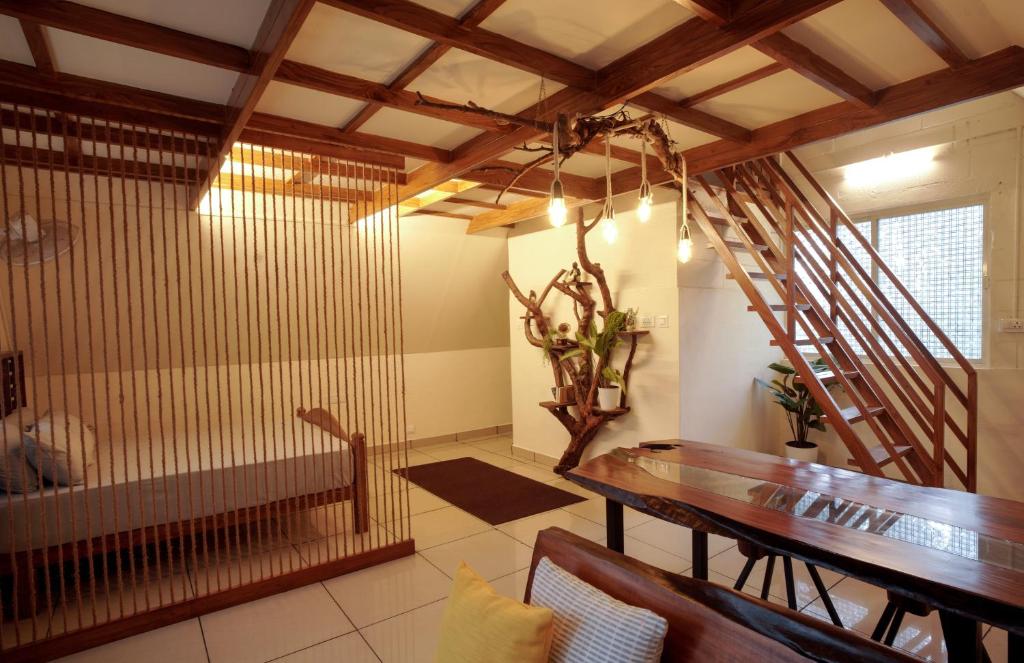 un comedor con una mesa de madera y una escalera en Tapovana - Hillside Retreat, en Thekkady