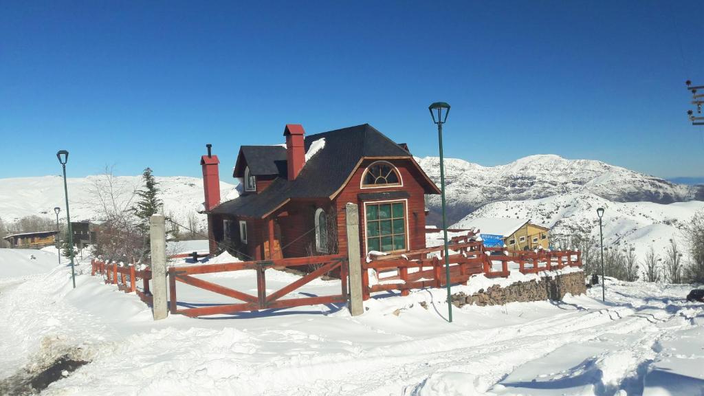 ein kleines Haus im Schnee mit einem Zaun in der Unterkunft Great Chalet Farellones in Farellones