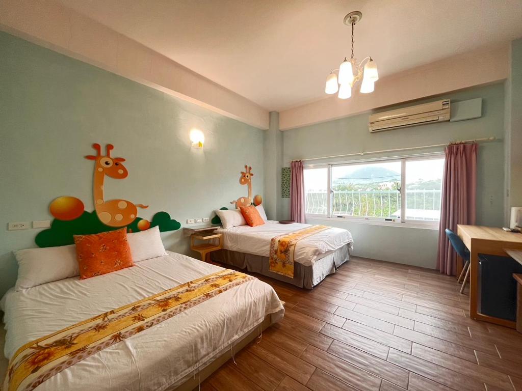 ein Schlafzimmer mit 2 Betten und einer Giraffe an der Wand in der Unterkunft 墾丁亞維儂莊園民宿 in Altstadt von Hengchun