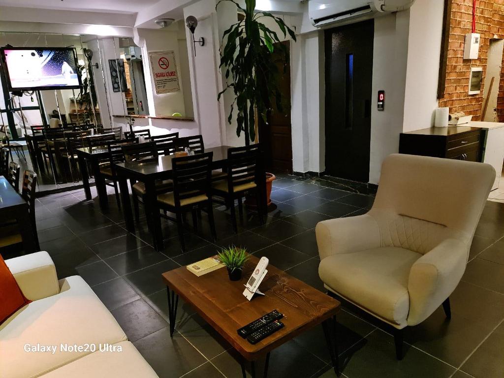 a dining room with a table and chairs and a coffee table at Paperon Butik Otel in Erdemli