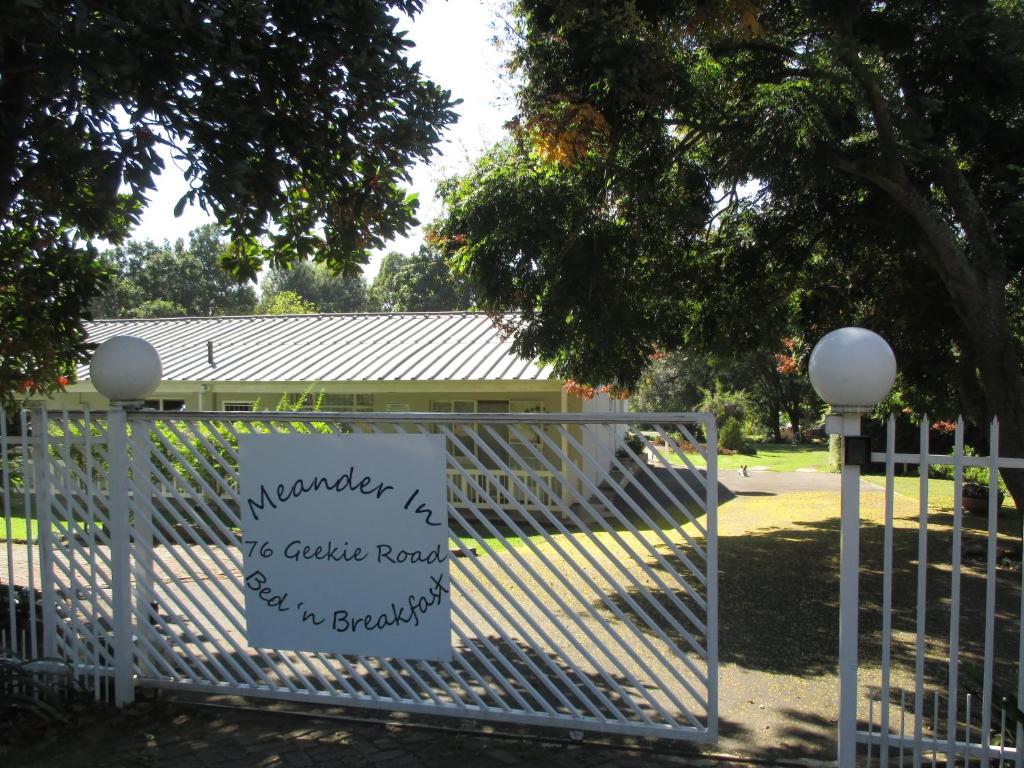 a sign on a gate in front of a building at Meander In in Howick