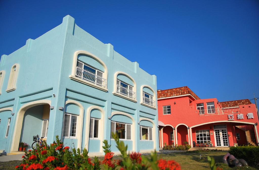 a group of colorful houses with flowers in front at 墾丁亞維儂莊園民宿 in Hengchun South Gate