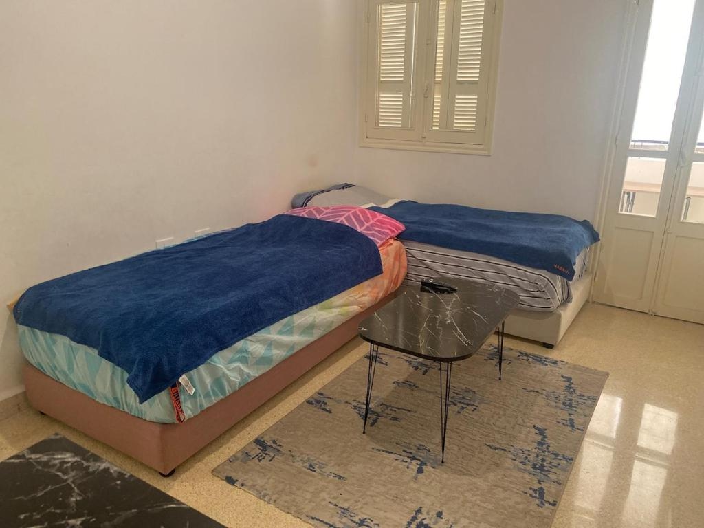 due letti singoli in una stanza con finestra di Smart Home a Baabda