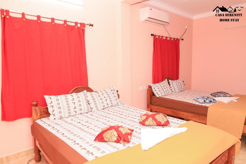 two beds in a room with red curtains at Spacious Family Space Near Serenity Beach in Puducherry