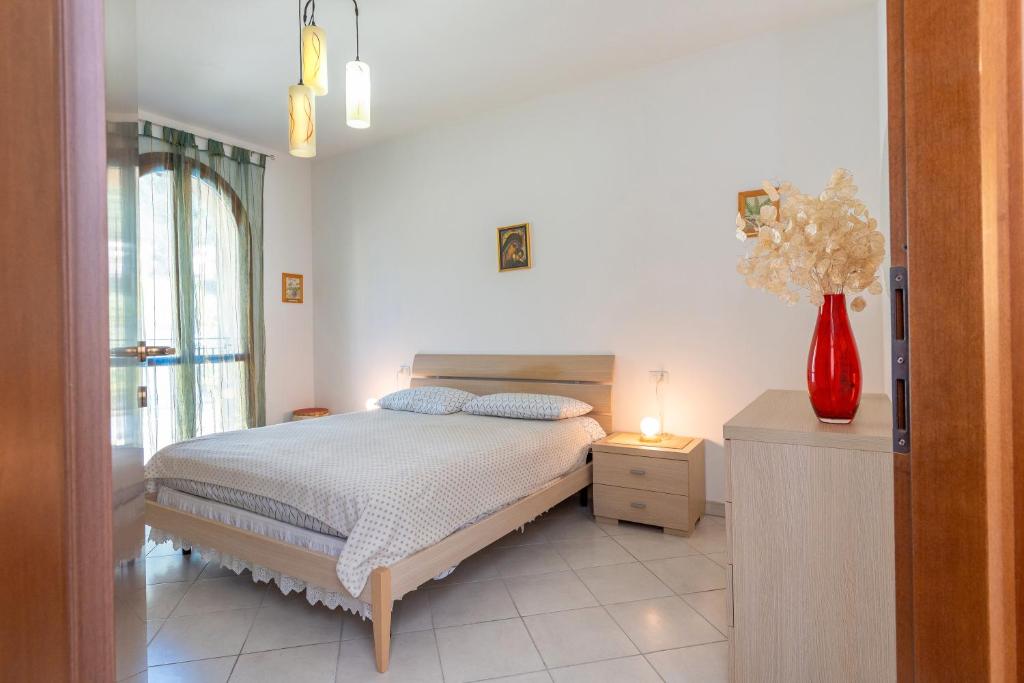 a bedroom with a bed and a vase of flowers at La Casa Dei Limoni in Piombino
