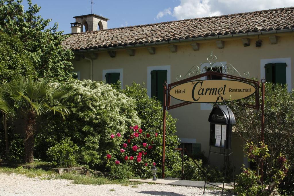 a sign in front of a house at Hotel Carmel in Les Vans