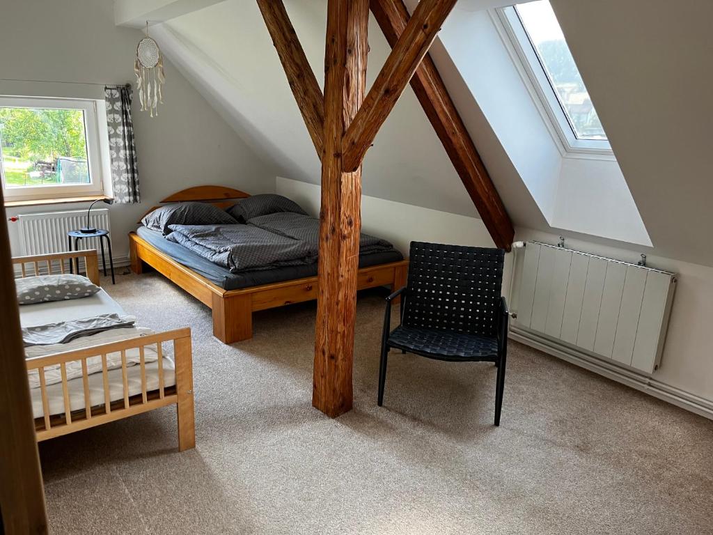 a bedroom with a bed and a chair in a attic at Chalupa U Lesa in Podmokly