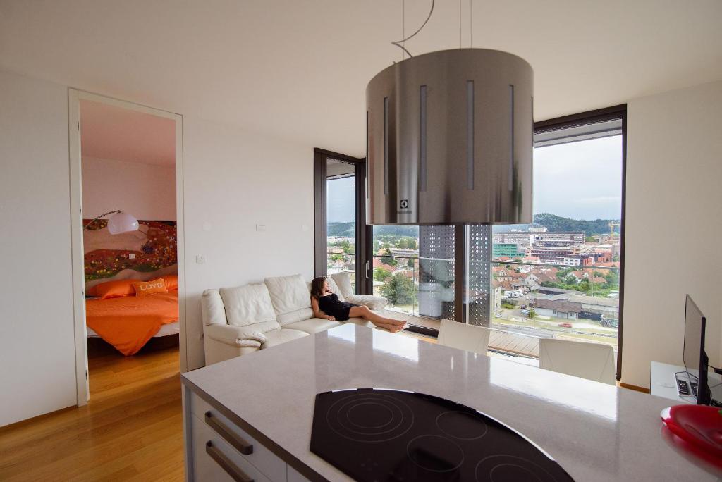 a woman sitting on a couch in a living room at Slovenia Crib in Ljubljana