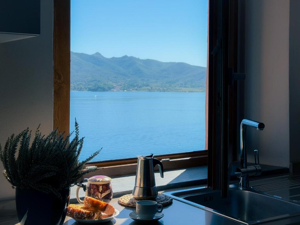 a kitchen sink with a view of the water at La Suite del Faro - HelloElba in Portoferraio
