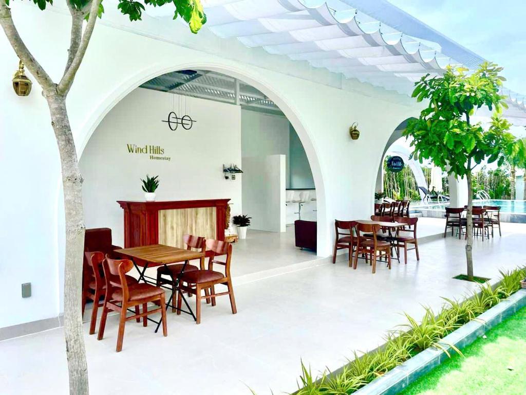 a dining area with tables and chairs in a building at Wind Hills in Ấp Nhơn Ðúc
