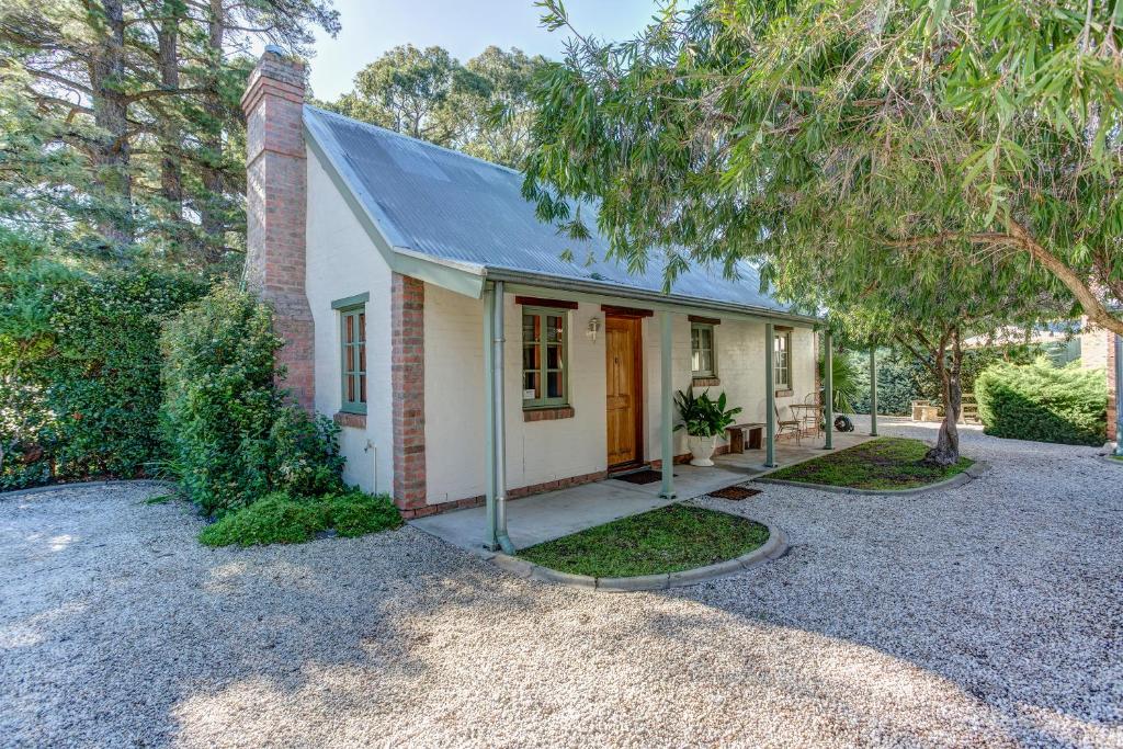 a small white house with a tree in front of it at Tanunda Cottages in Tanunda