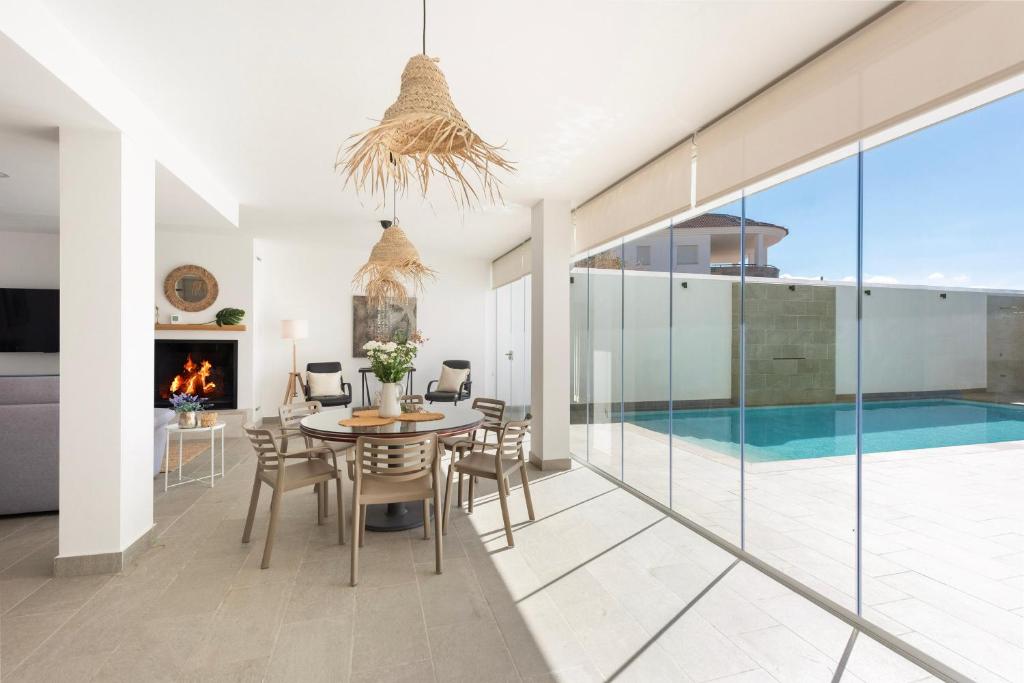 a dining room with a table and chairs and a fireplace at Casa B y G in Pizarra
