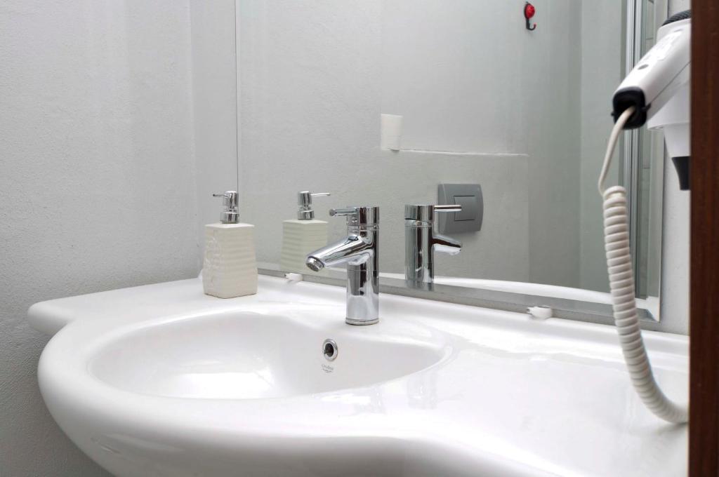 a white sink in a bathroom with a mirror at Paperon Butik Otel in Erdemli