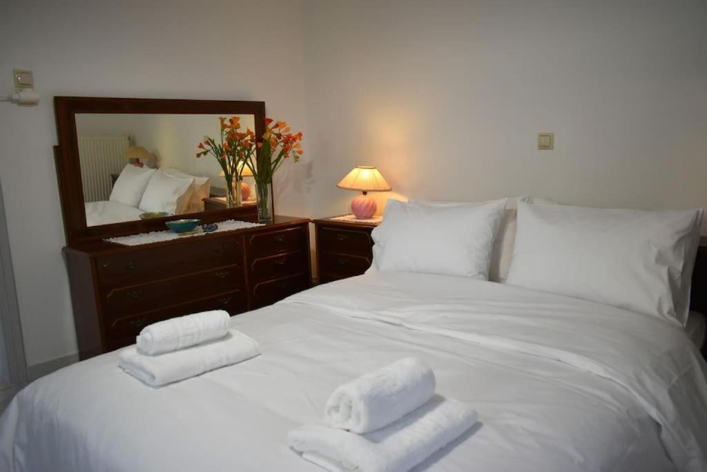 a bedroom with a white bed with towels on it at Avli Guesthouse 