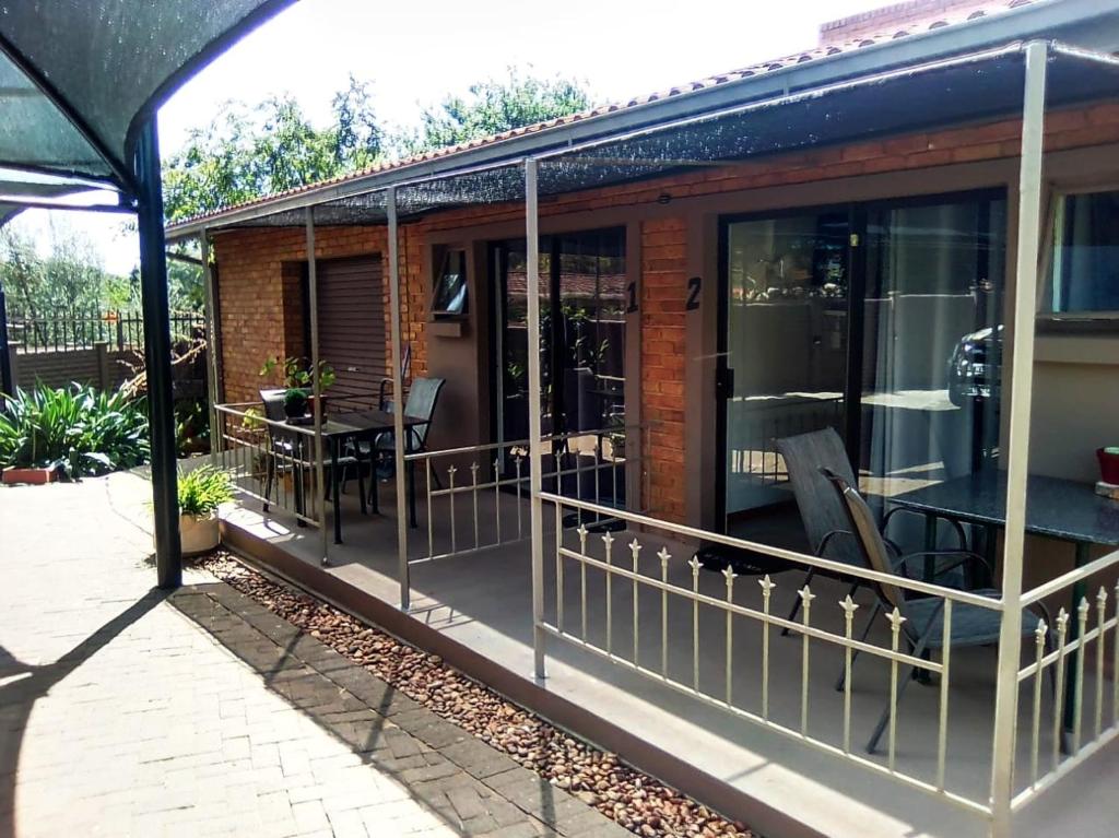 a screened in porch of a house with a table and chairs at Magalies B&B LANGENHOVENPARK in Universitas