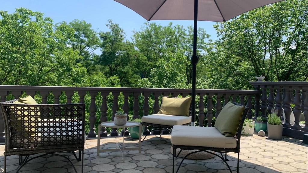 a patio with two chairs and an umbrella at Tri Tresnje & Three Cherries in Grabovnica