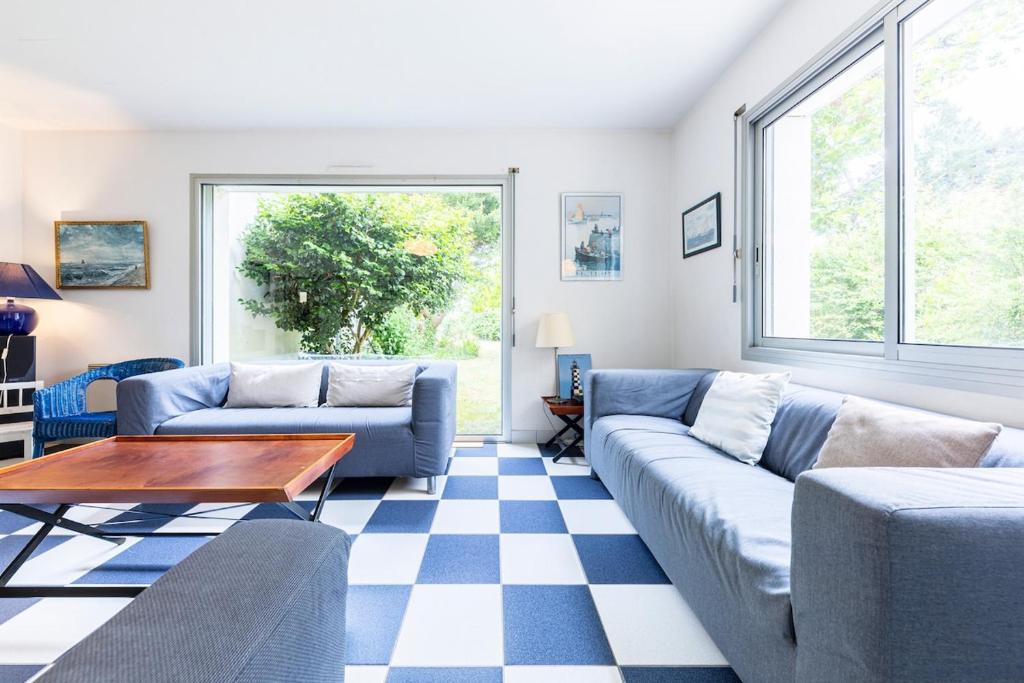 a living room with two couches and a table at Family vacation home 100 m from beach - Ty For Tous in Île-Tudy
