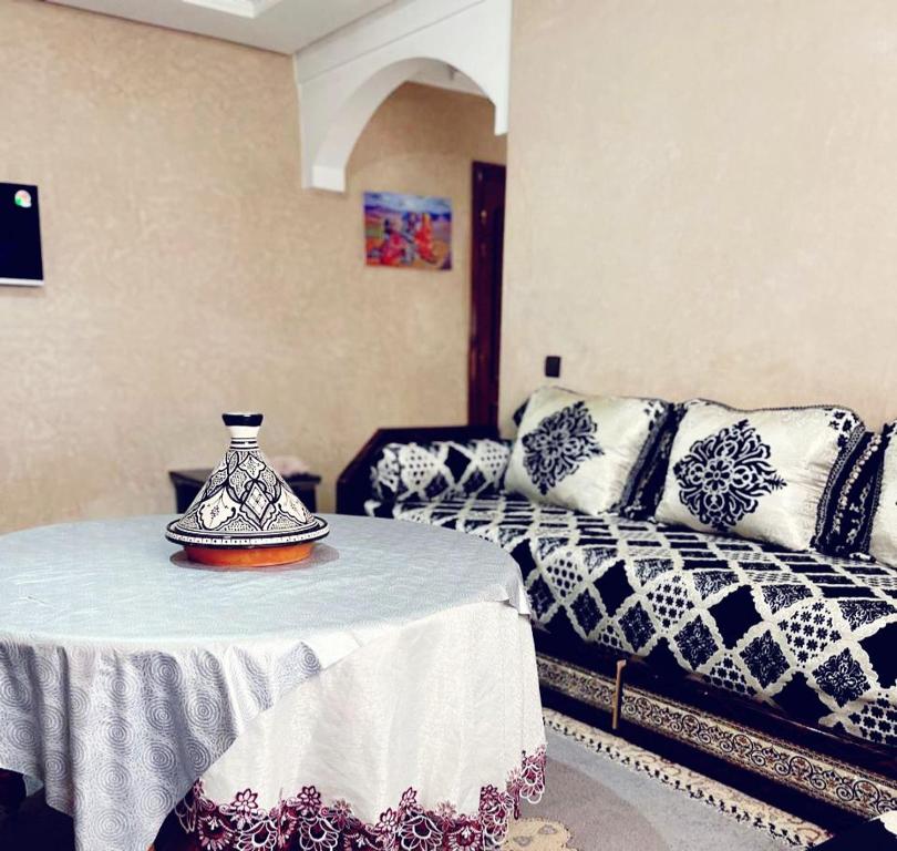 Pokój z łóżkiem i stołem z wazonem w obiekcie Bel appartement 2 chambres au cœur de Marrakech w mieście Oulad Akkou
