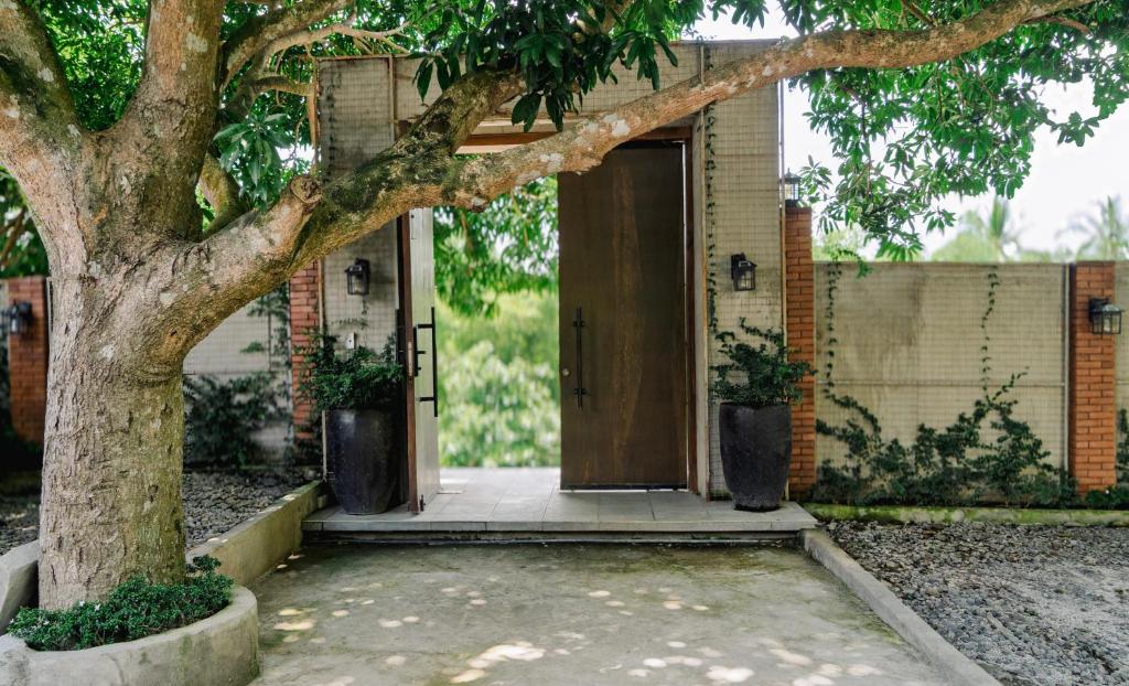 a door to a house with a tree at The Getaway Bailen in General Emilio Aguinaldo