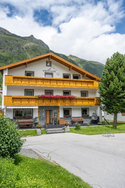 a large white building with mountains in the background at Vermunt - Silvretta Premium Card von Juli bis September in Galtür