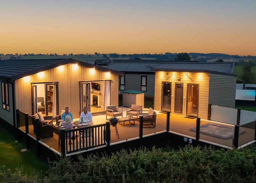 two people sitting on the deck of a house at Heathergate Boutique Holiday Park in Hexham