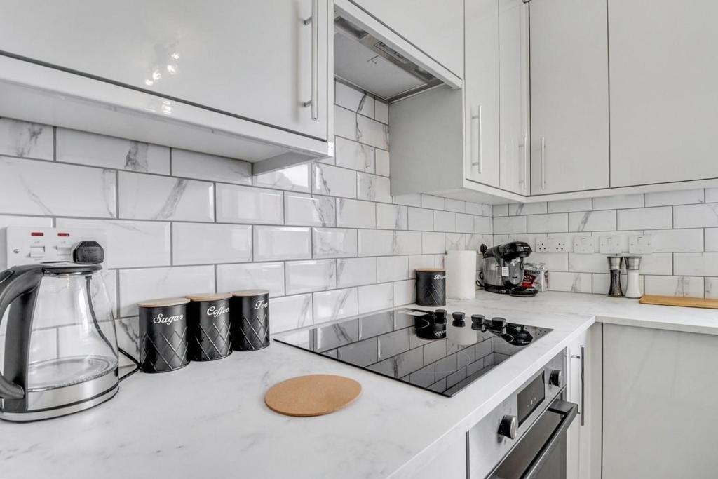 a kitchen with white cabinets and a counter top at Modern 3Bed Escape - Work&Relax - Free Parking in Chigwell