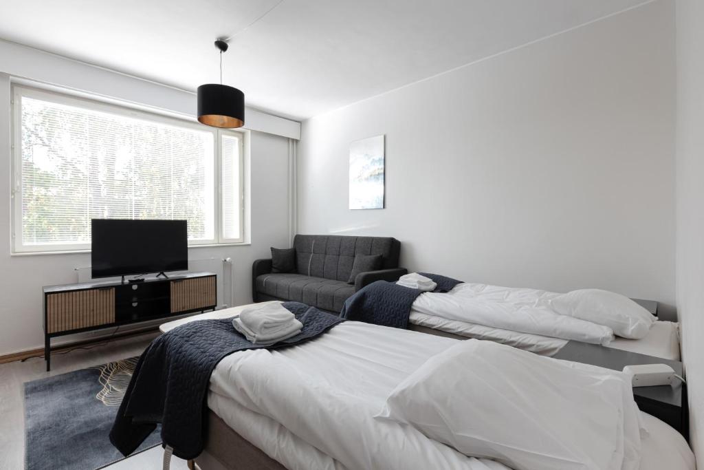 Un pat sau paturi într-o cameră la Kotimaailma Aparthotel Ankkuri - 4 Bedroom