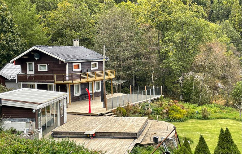 une maison avec une grande terrasse devant une cour dans l'établissement 3 Bedroom Cozy Home In Farsund, à Helle