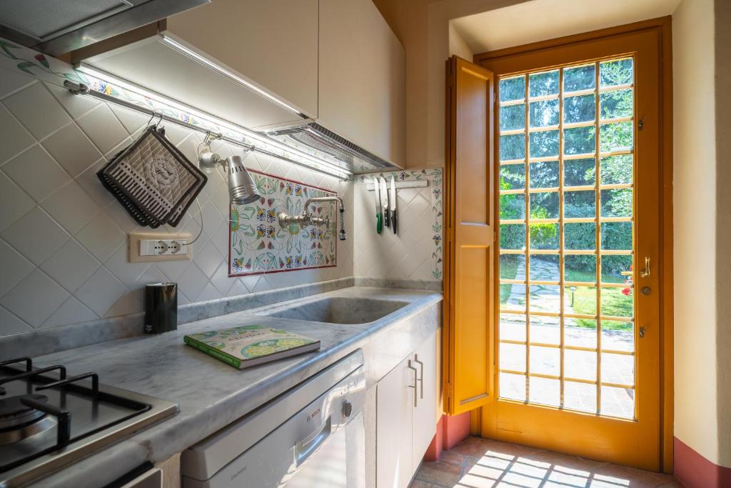Una cocina con fregadero, estufa y ventana. en Bertolli Villas, en Matraia