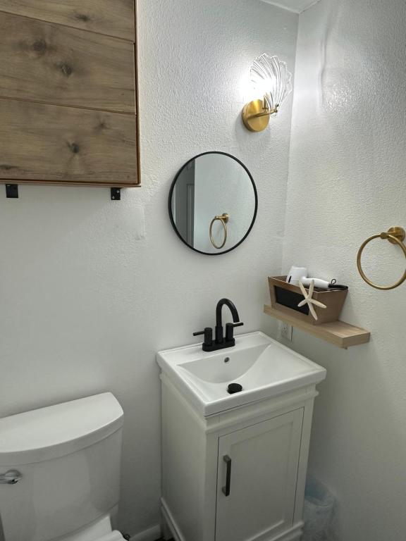 Un baño con inodoro, lavabo y espejo. en Happy Hill Inn, en Kailua-Kona