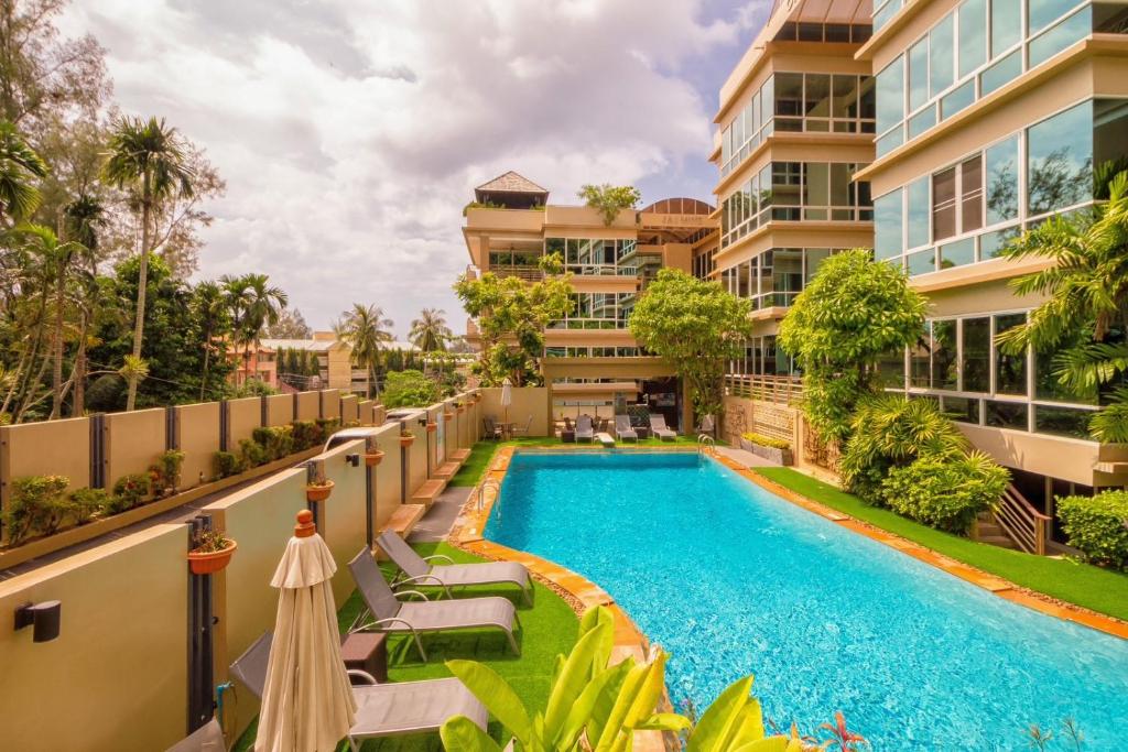 an apartment with a swimming pool and a building at Karon Beach Seaview Penthouse With Private Pool Condominium in Karon Beach