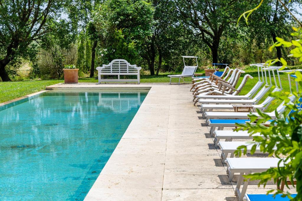 een rij ligstoelen naast een zwembad bij Villa Federica 17 in Manciano