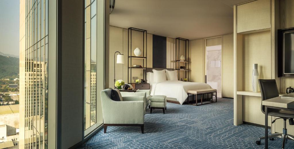 a hotel room with a bed and a desk and chairs at Four Seasons Hotel Seoul in Seoul