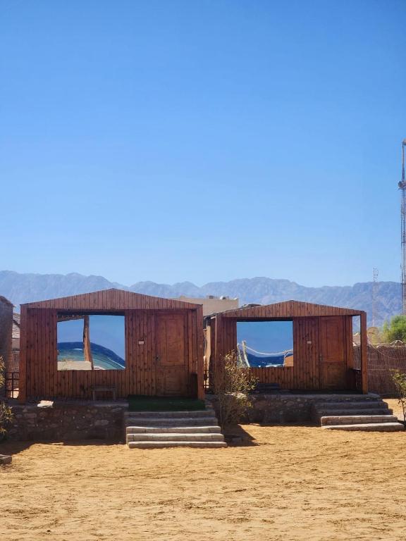 a building with steps and windows with mountains in the background at Southern spirit in Nuweiba