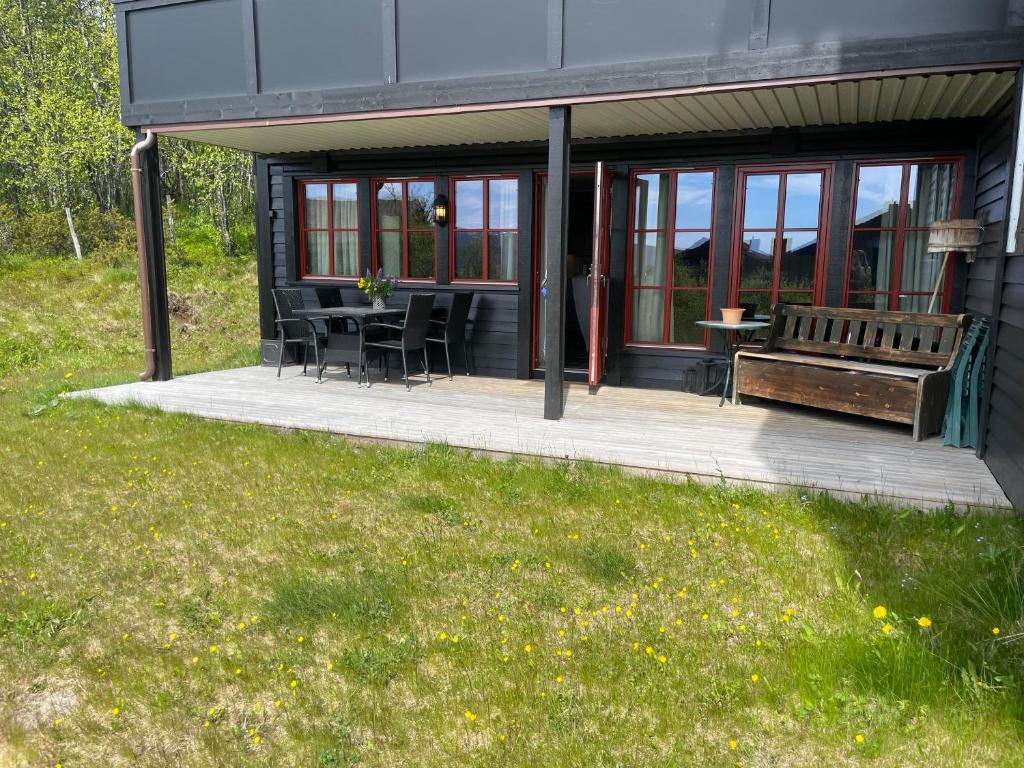 a house with a bench and a table and chairs at Nice And Central With Terrace in Beitostøl
