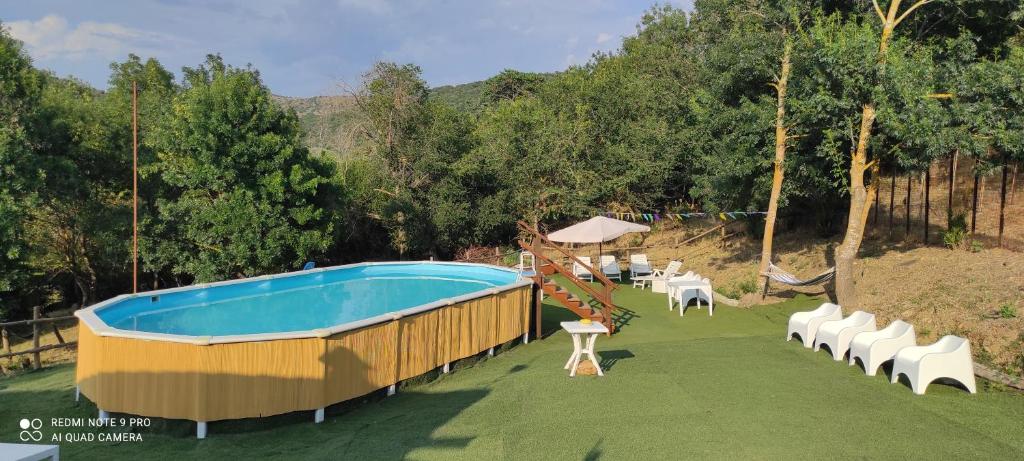 a large swimming pool with chairs and a slide at DIMORA IL CAMALEONTE country apartments with pool in Civitavecchia