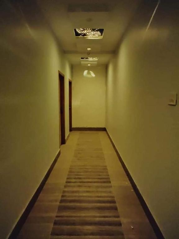 an empty hallway with a ceiling with a long aisle at Canal View Hotel in Dargai