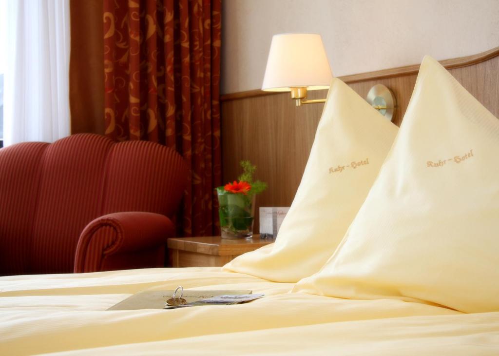 a hotel room with a bed with two white pillows at Altes Gasthaus Kuhr - Hotel & Restaurant in Papenburg