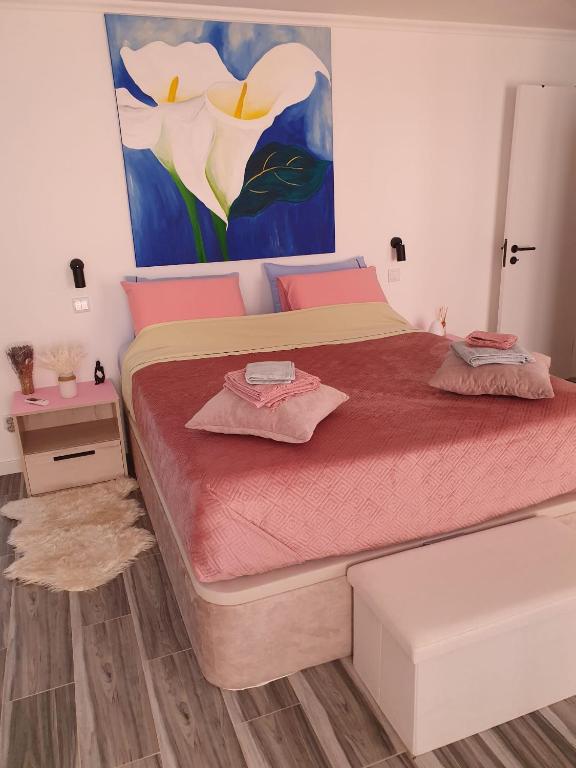 a bedroom with a large bed with a painting on the wall at Casa do Arelho in Óbidos