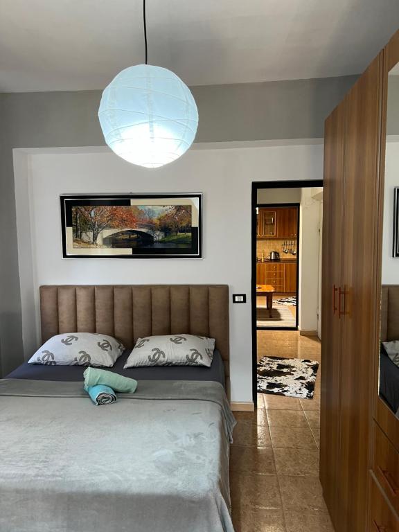 a bedroom with a large bed and a large light fixture at Temali Apartment 3 in Shkodër
