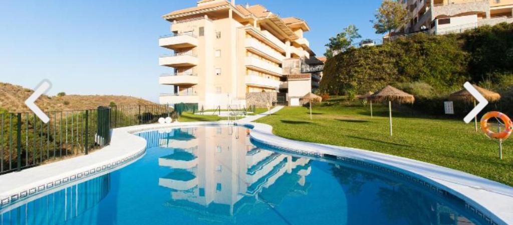 una grande piscina di fronte a un edificio di Don Juan III a Fuengirola