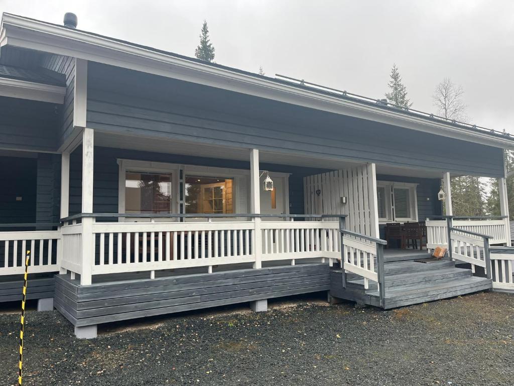 ein blaues Haus mit einer großen Veranda mit einem weißen Geländer in der Unterkunft Ruka Snow&Sun 3 - 2 ski tickets included in Kuusamo