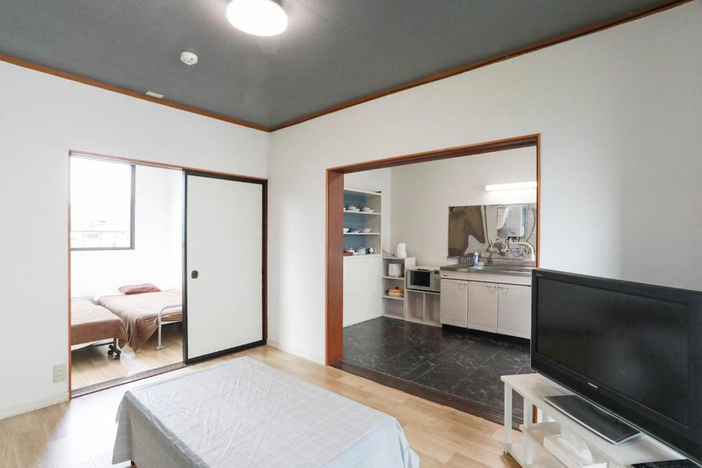 a living room with a large flat screen tv at ひだまりの宿 まゆしょう in Omachi