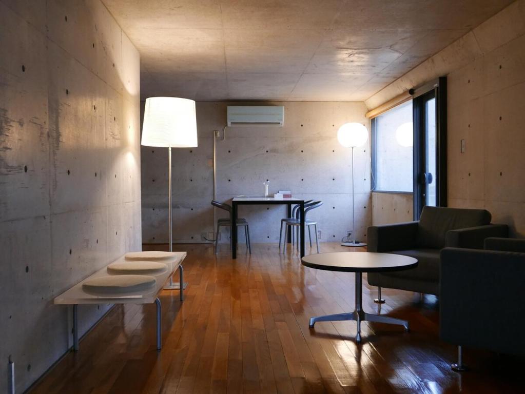 生駒市にあるOne Floor Designed by Architect Tadao Andoのテーブル2つとソファのあるリビングルーム