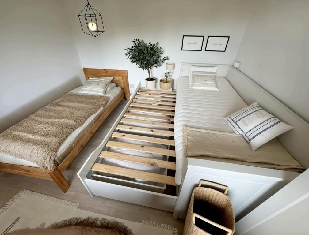 twee bedden in een kleine kamer met een trap bij Villa Horizon in Lacanau