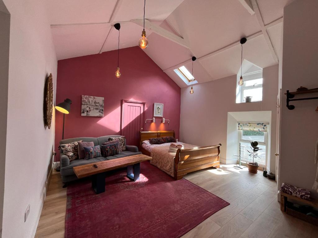 a living room with a couch and a table at Cosy Northumberland Studio Cottage in Thropton