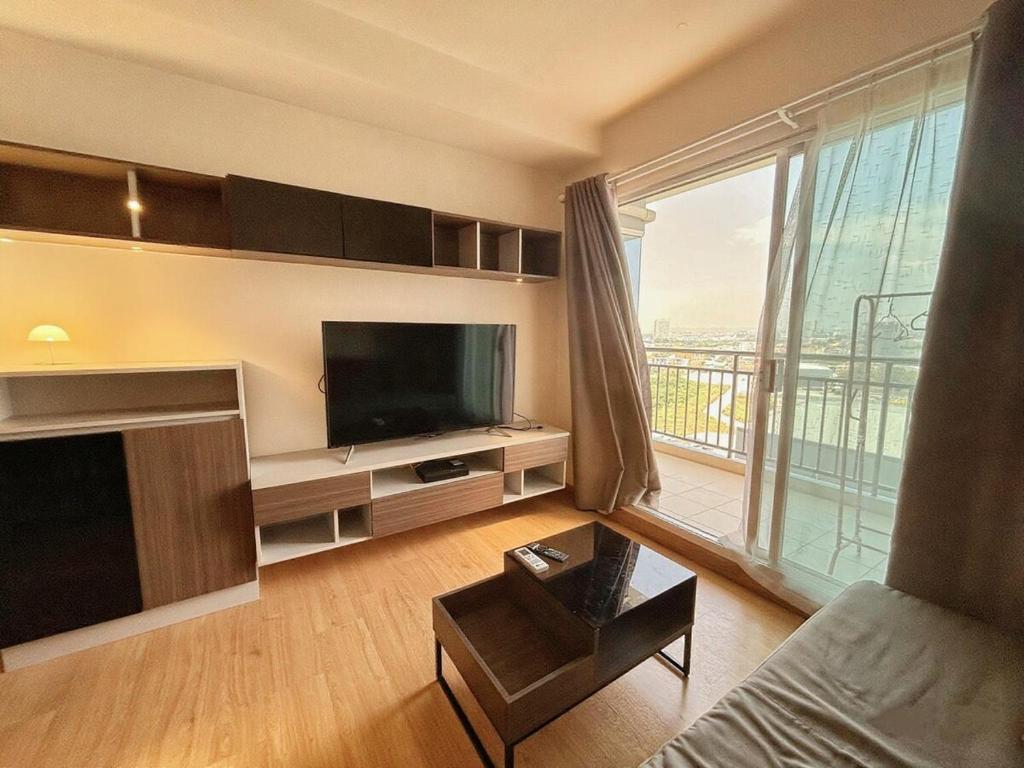 sala de estar con TV y ventana grande en 芭提雅市中心大空间公寓酒店预定 城景健身房泳池舒适型公寓 日租周租月租灵活, en Pattaya South