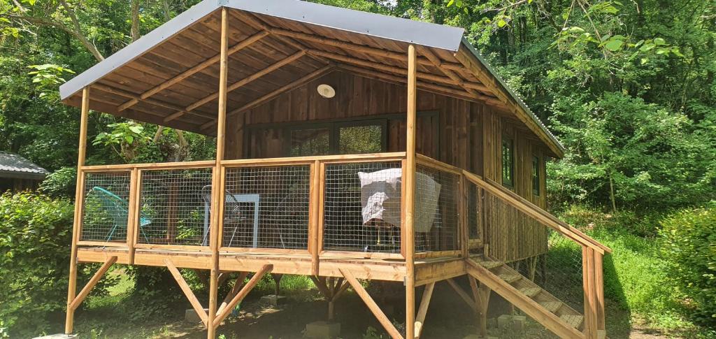 a large wooden bird cage with a roof at Camping le Moulin de David -Gaugeac Monpazier 24540 - Cabane -Mobil-home 3 et 2 chambres in Gaugeac