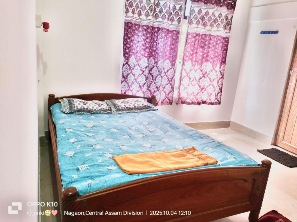 ein Schlafzimmer mit einem Bett mit einer blauen Bettdecke in der Unterkunft Good luck homestay 