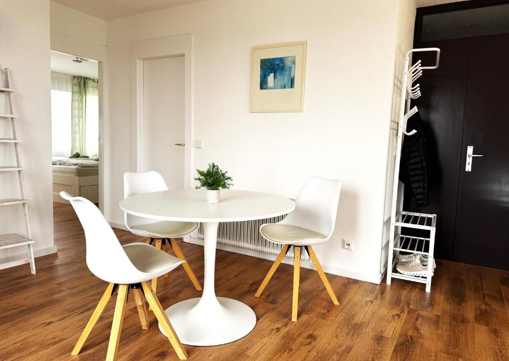 a dining room with a white table and white chairs at Gemütliche Ferienwohnung mit großer Dachterasse in Offenburg